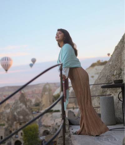 Woman watching hot air balloons during solo travel in Cappadocia.