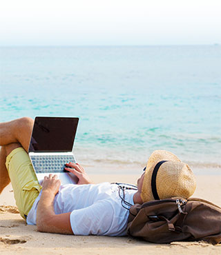 man on beach with laptop