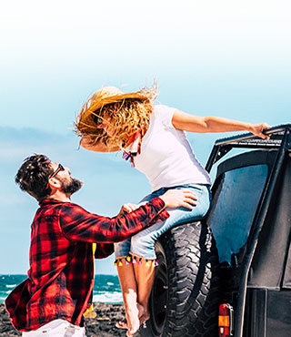 Couple on a beach road trip with rental car insurance coverage 