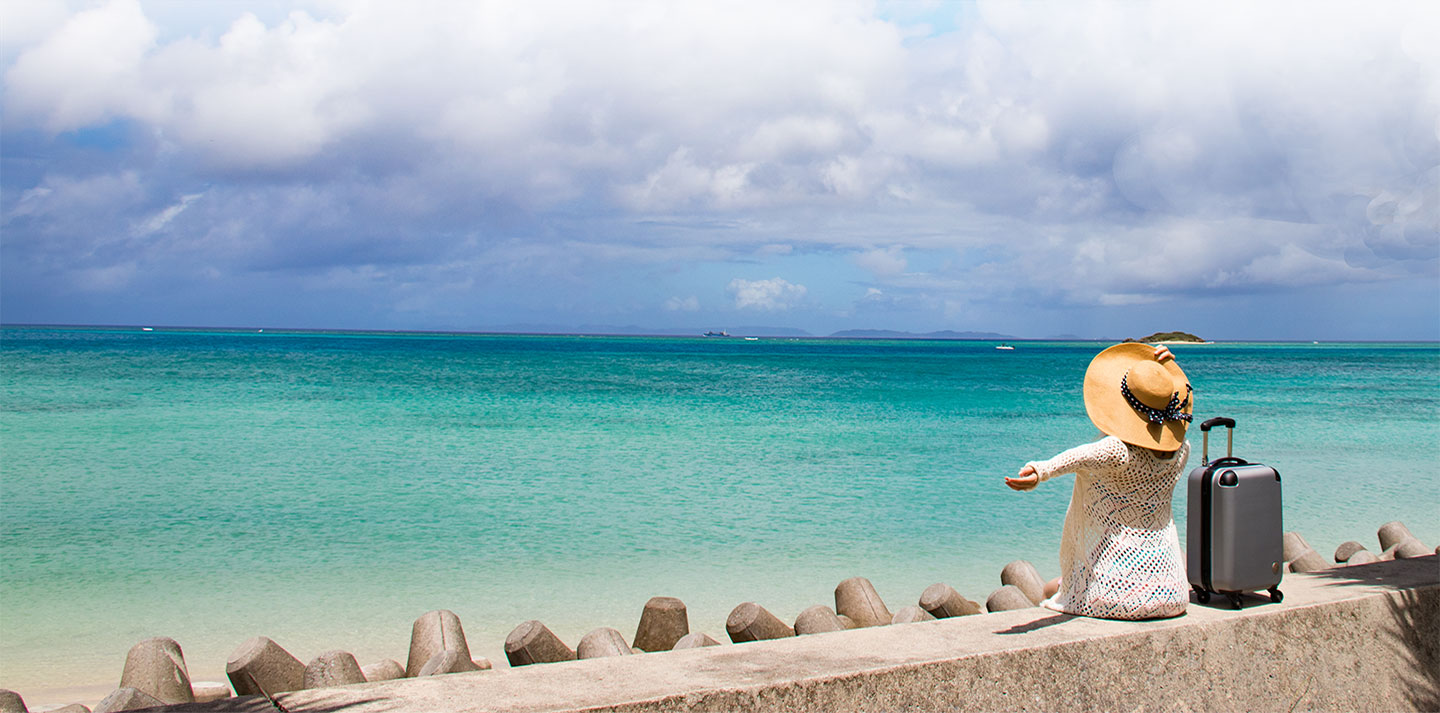 woman at beach with luggage