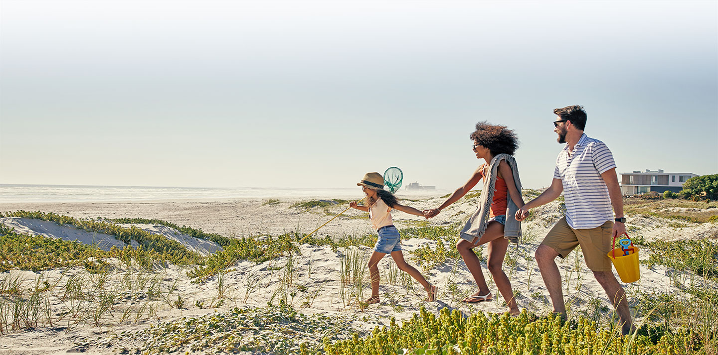 young family walking to beach