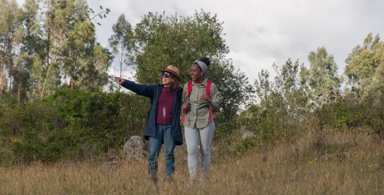 A couple hiking on a grassy hill during their trip, which may be to one of the most romantic places in the world.