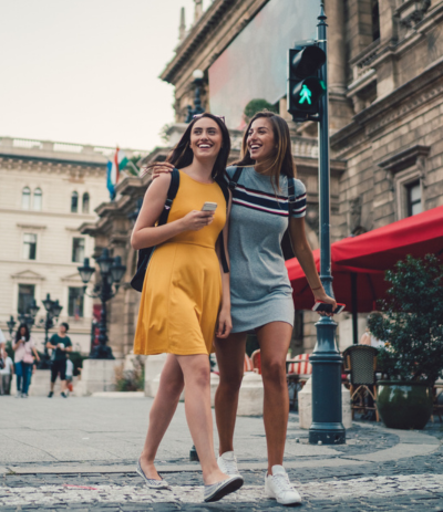 Two girls crossing the street during their student travel.