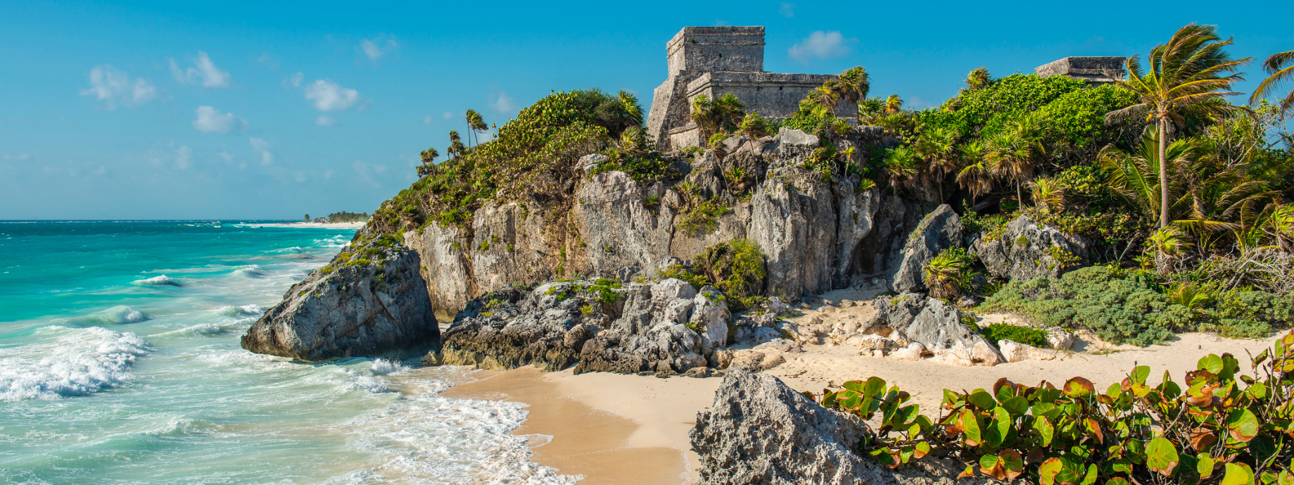 Mayan ruins in Tulum on a cliff overlooking the beach where you can travel with travel insurance for Mexico