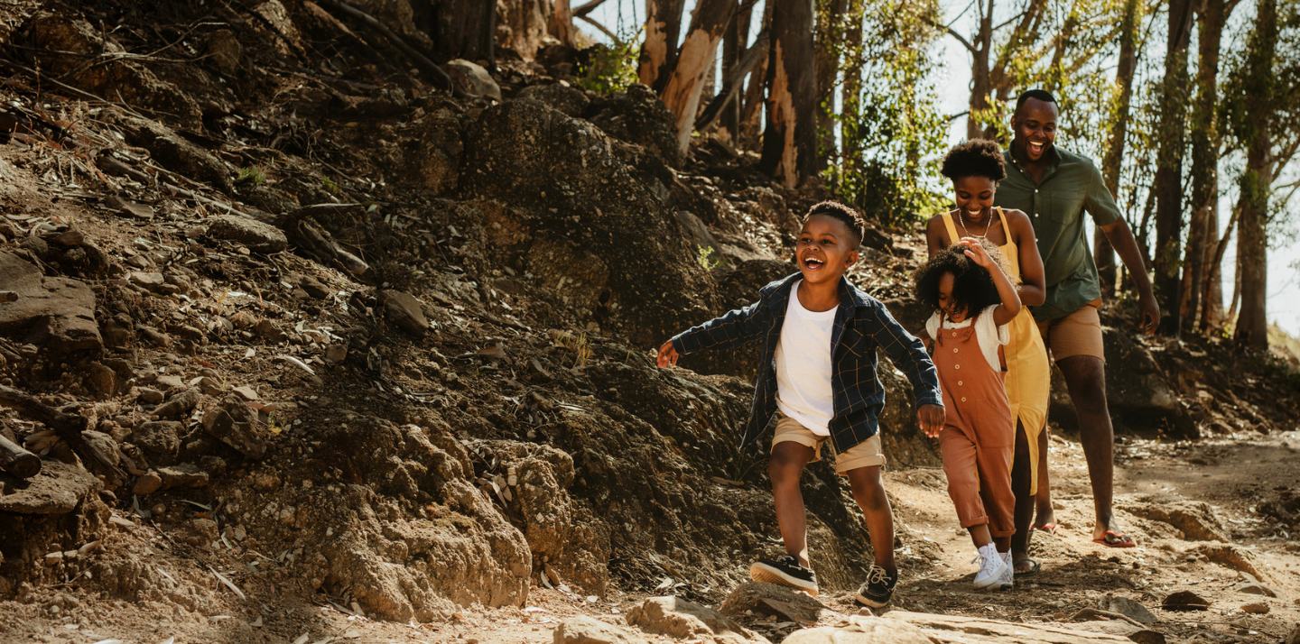 Family smiling on a hike at home with any reason cancellation travel insurance