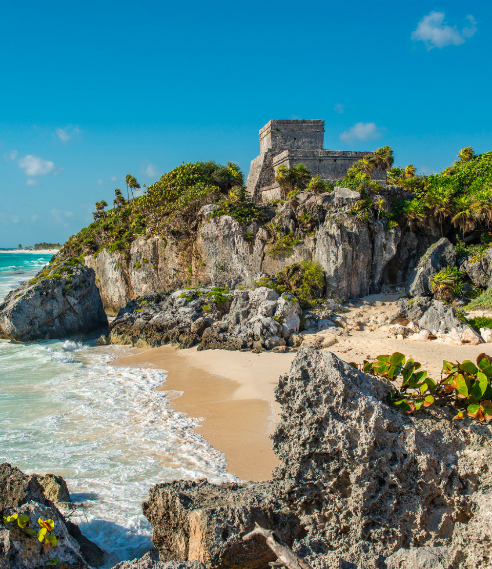 Mayan ruins in Tulum on a cliff overlooking the beach where you can travel with travel insurance for Mexico