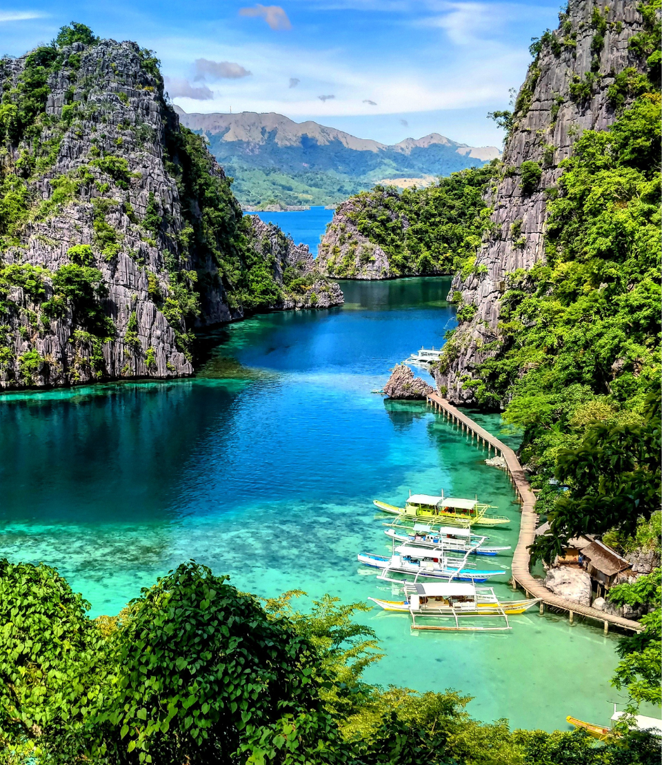 Kayangan Lake with boats and surrounding hills, where you can travel with travel insurance for the Philippines