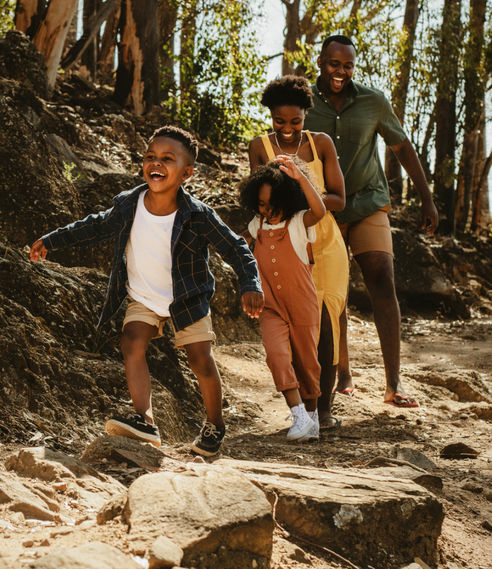 Family smiling on a hike at home with any reason cancellation travel insurance