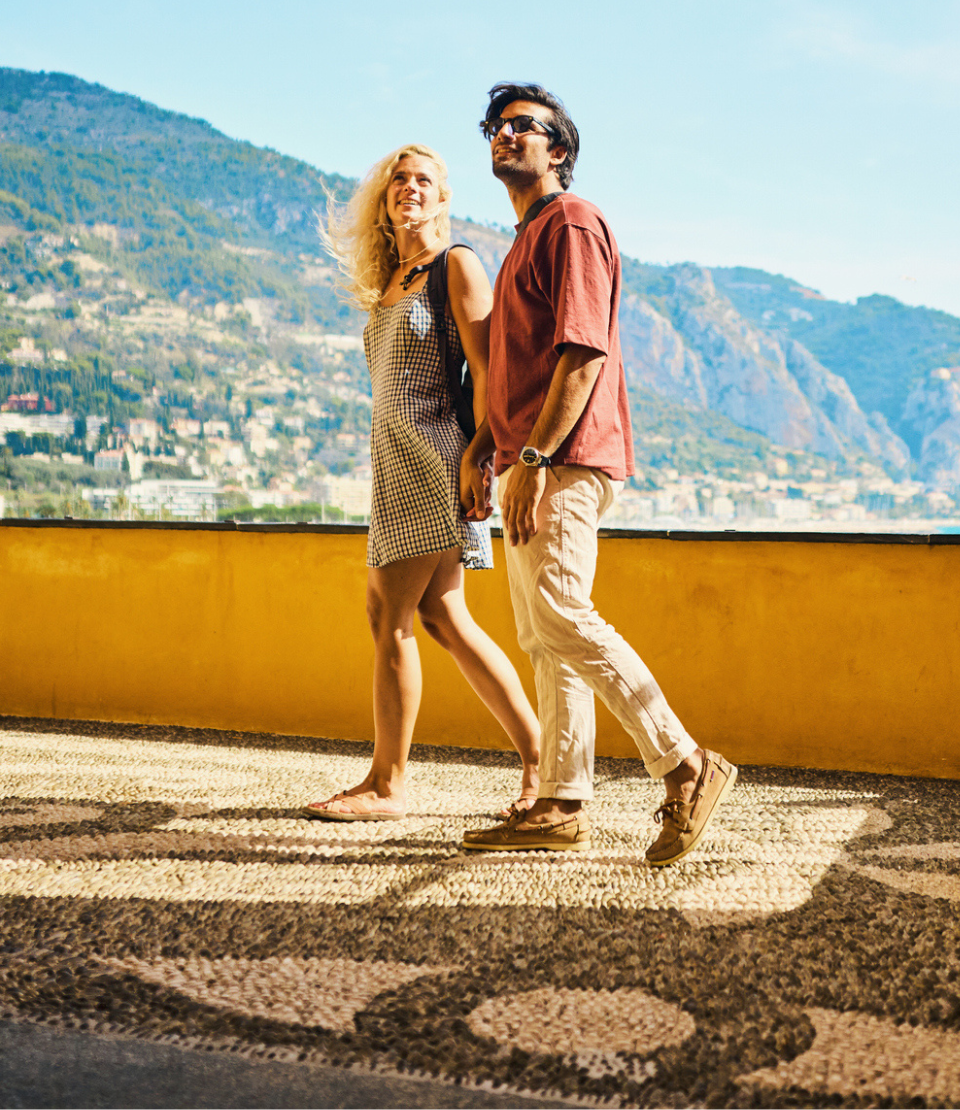 travel insurance page image of couple holding hands with hills in background