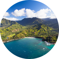 Aerial view of mountains, beach, and ocean in Kauai, where you can travel with Hawaii travel insurance