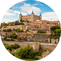 View of Toledo and Puente de Alcantara over Targus River, where you can travel with travel insurance for Spain