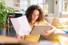 Woman seated on floor analyzing paperwork