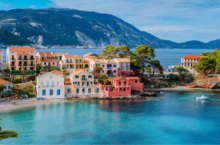 Read our Europe travel guide before traveling to see this view of Assos village in Greece with colorful houses and a lagoon.