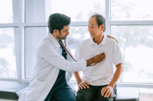 Doctor checking patient&#039;s heart at a travel health care appointment