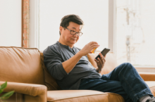 Man looking at prescription medication and holding his smartphone.