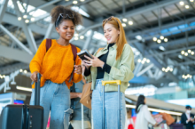 Two women in an airport, with one trying not to lose her passport.