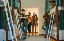 Four travelers settling into bunk beds